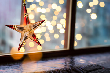 Glass Christmas star with Christmas lights in the background. Space for text