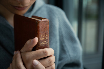 Young woman praying to god with the bible, Concept of faith for god.
