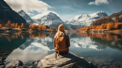 Traveler Admiring Autumn Lake Beneath Majestic Snow-Capped Mountains - obrazy, fototapety, plakaty