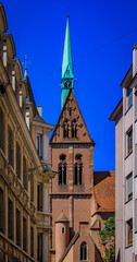 Fototapeta na wymiar View onto the facade and tall spire of the Saint Pierre le Jeune Protestant church on Grande Ile, historic center of Strasbourg, Alsace, France