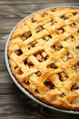 Homemade sweet american apple pie with sugar and cinnamon. Tart on brown wooden background.