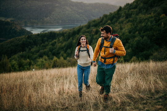 A sweet image of a loving couple, wearing their camping backpacks as they wind down from a day of adventure