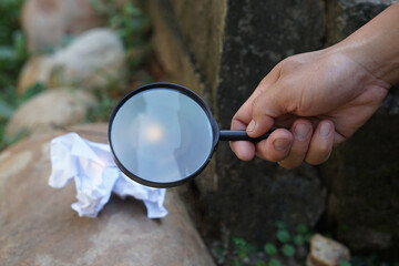 Close up hand hold magnifying glass to make fire for burning paper. Concept, Science experiment...