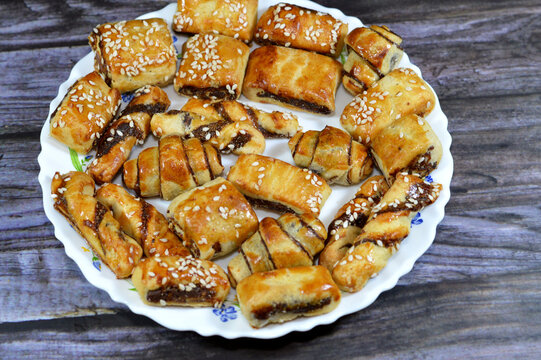 Pastry stuffed with dates and topped with sesame seeds or Ka'ab El Ghazal, Egyptian date or Agwa Ajwa filled cookies, famous middle eastern date filled pastries covered with sesame, selective focus