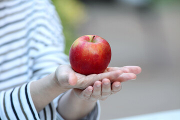 Woman holding an apple in her hands close-up