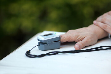 Woman with pulse oximeter in her hand close-up