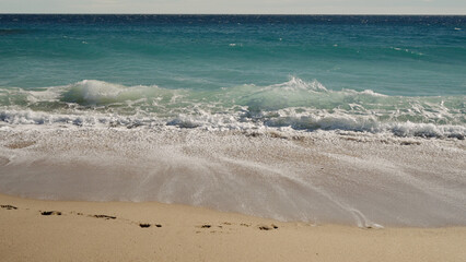 blue waves on a sandy empty beach in Cannes in spring