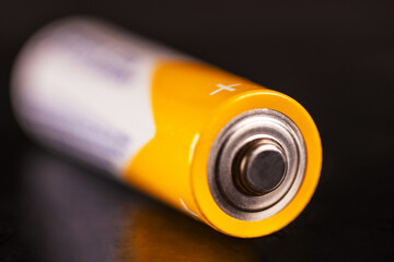 AA battery, close-up photo on black background, shallow depth of field
