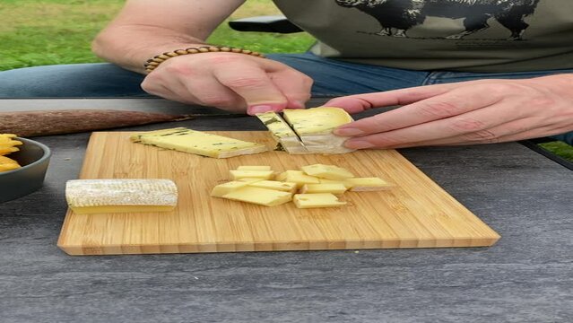 D&eacute;coupe de fromage &agrave; p&acirc;te dure en cubes sur une planche en bois pour l'ap&eacute;ritif