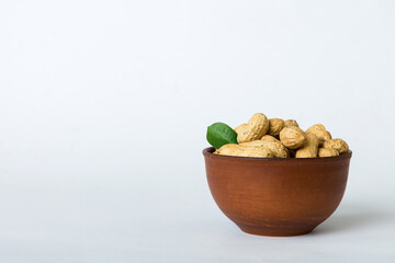 Fresh healthy peanuts in bowl on colored table background. Top view Healthy eating bertholletia concept. Super foods