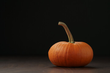 Small orange pumpkin for halloween on wood table