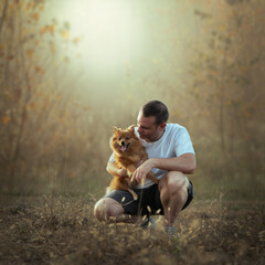 Forty year old man in the woods with his dog in a fairy tale atmosphere, bonding between man and...