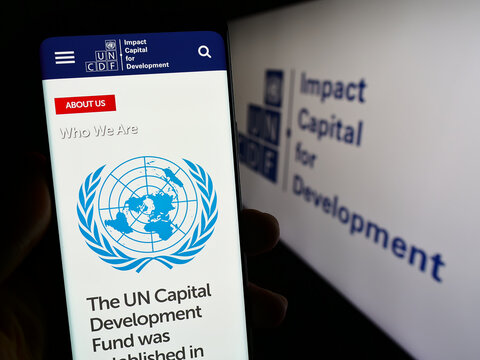 Stuttgart, Germany - 09-25-2023: Person holding smartphone with webpage of United Nations Capital Development Fund (UNCDF) in front of logo. Focus on center of phone display.