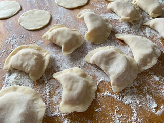 Raw ravioli pasta on table with flour. Macro, Fresh Made Cheese Ravioli, handmade at home.