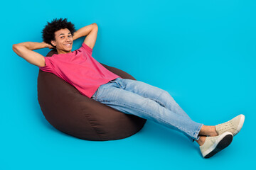 Full length photo of nice young guy lying sit soft beanbag hands behind head dressed stylish pink...