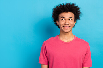 Photo of satisfied friendly man wear pink outfit watching empty space isolated on blue color background