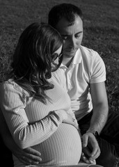 Profile portrait of a beautiful couple posing together in nature. Black and white image.