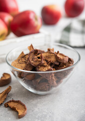 Bowl with dried brown apple slices and red ripe apples in box.Macro.