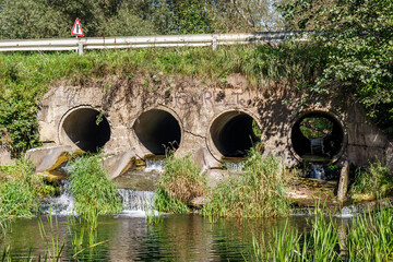 Culvert system of four pipes on the river under the road