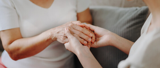 Asian female hands touching old female hand Helping hands take care of the elderly concept - obrazy, fototapety, plakaty