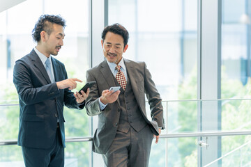 スマホを見せるビジネスマンたち