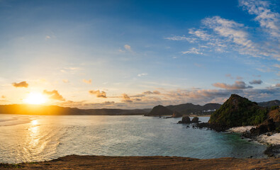 Fototapeta premium beautiful sunset landscape at tropical beach in Lombok, Indonesia. Bright sunset landscape near Kuta beach area, Lombok, Indonesia