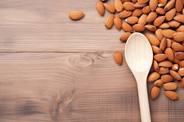 Almond nuts in wooden spoon on wooden background. Top view with copy space - obrazy, fototapety, plakaty