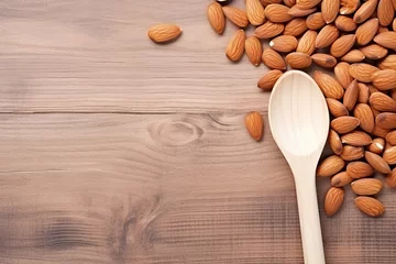 Fotobehang Almond nuts in wooden spoon on wooden background. Top view with copy space © ttonaorh