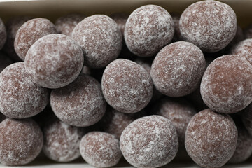 Fototapeta na wymiar Round chocolate candies in powdered sugar, close up