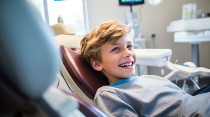 At the doctor. Happy child sitting in a dental chair with a smile on his face. Dental health concept, medicine, prevention. - obrazy, fototapety, plakaty