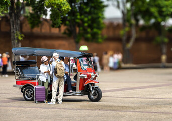 Senior tourist couples talking with tuktuk driver during summer vacation at Tha Pae gate,...