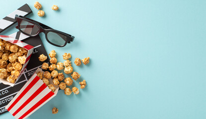 Anticipating the filmstrip's debut. Top-view shot of producer's clapper, 3D eyewear, delectable popcorn scattered from striped boxes on light blue backdrop with available space for text or promotion - obrazy, fototapety, plakaty