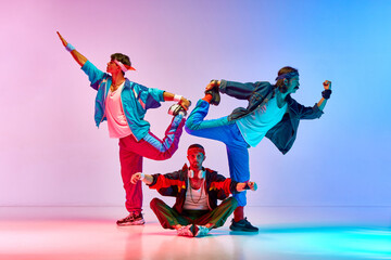 Funny, athletic young men in vintage sportswear training, doing stretching exercises over gradient...