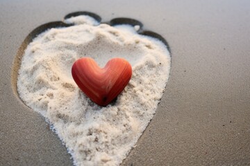 Fototapeta premium a heart drawn in the sand next to neat pebbles placed in a heart shape