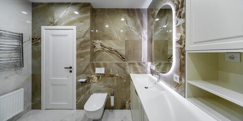 Bright bathroom with stone tiles on the walls. Modern bathroom interior.