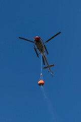 Bottom view of a firefighting helicopter in flight