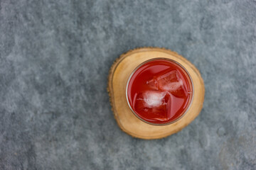 A glass of fresh watermelon juice was placed on a wooden coaster. Top view
