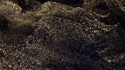 Black glitter with gold flecks. Golden loosened sand on ground.