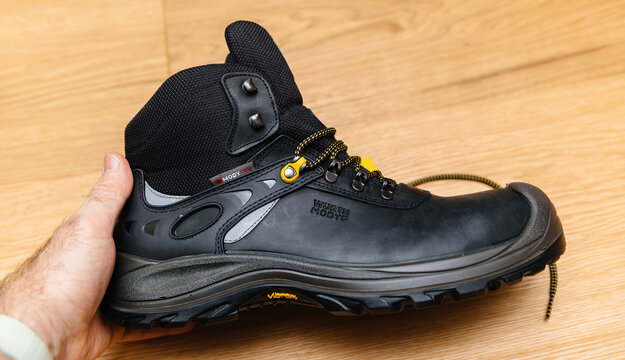 Hamburg, Germany - Feb 16, 2022: Hand holding Wurth Modyf working protection shoes with leather sole, toenail protection, and acid resistance for demanding work environments