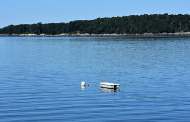 Dinghy Anchored in the Waters off an Island