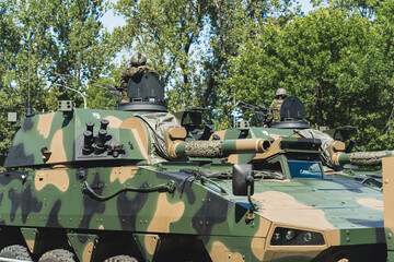 Military forces concept. Two smaller battle tanks with soldiers on top against the background of...