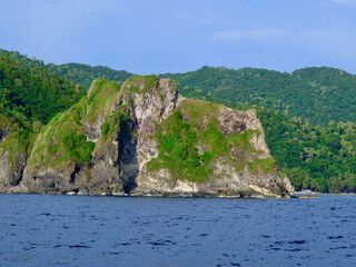 Fototapeta na wymiar Rocky coast of a tropical island. Steep cliff on the ocean shore.