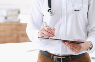 Male medicine doctor hand holding silver pen and clipboard pad closeup. Ward round patient visit check medical calculation and statistics concept physician ready to examine patient - obrazy, fototapety, plakaty