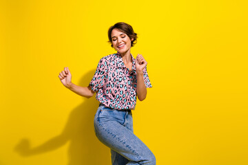 Photo of gorgeous cheerful girl toothy smile enjoy dancing partying isolated on vibrant yellow...