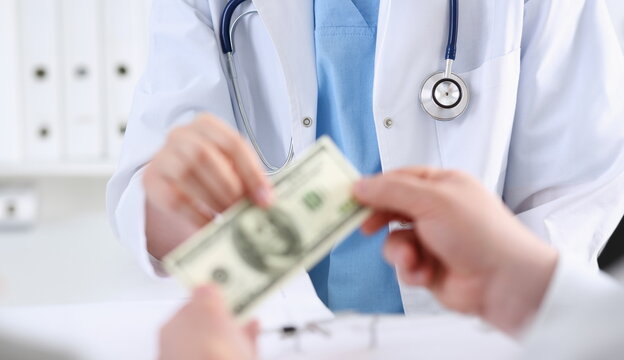 Female doctor hold in hands bunch of hundred dollars banknotes take or give them. Prestige and high paid job encash treatment illegal drug fraud anonymous visitor private visit reform concept