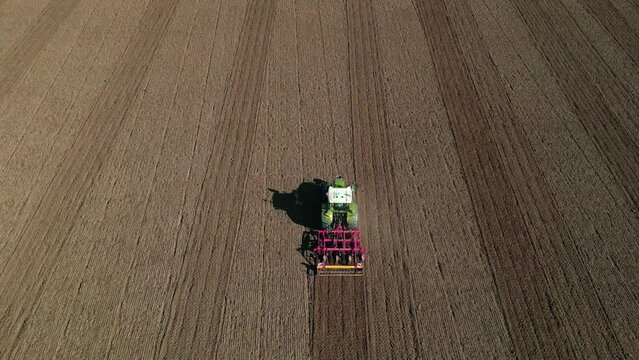 Ein Traktor pfl&uuml;gt ein Feld von oben gesehen
