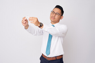 Angry young Asian businessman breaking cigarettes and saying no to smoking isolated on white background