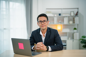 Smart Asian businessman with suit smiling wearing glasses working with computer laptop. concept...