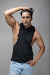 Indian young male model in casual wear wearing black tshirt and blue torn denim jeans. Male model. Fashion Portrait.