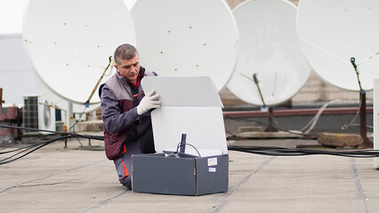 An engineer installs satellite internet antennas. Work process of modernization of telecommunication equipment. Concept of modern technologies and successful business.